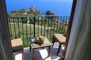 a table with a bowl of fruit on a balcony at Torre Bennistra in Scopello