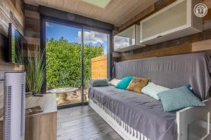 Bett in einem Zimmer mit Glasschiebetür in der Unterkunft Trois Six Vendée in Toulon-sur-Arroux