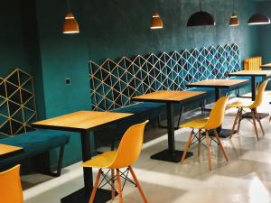 a row of tables and yellow chairs in a restaurant at Green Rooms in Kutaisi