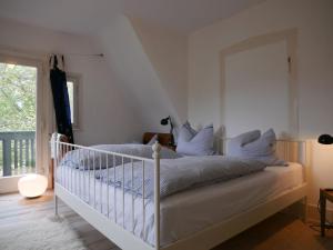 a bedroom with a white bed with a mirror at Villa Himmelsblau in Bad Herrenalb