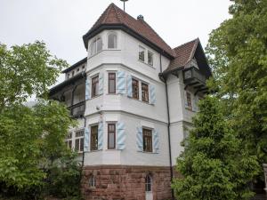 un alto edificio bianco con tetto di gamberetti di Villa Himmelsblau a Bad Herrenalb