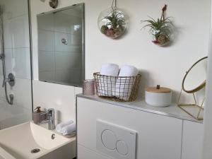a white bathroom with a sink and a mirror at Kal's Studio Apartment Salzburg in Salzburg +36 photos