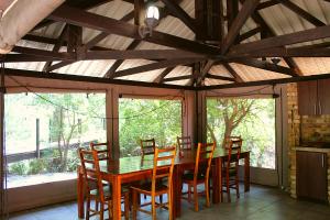 a dining room with a wooden table and chairs at Casa Cara Resort in Parys