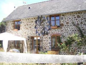 a stone house with windows and a table in front of it at La Cloue in Sainte-Marie-du-Bois