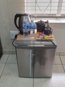 a counter with two water bottles on top of a appliance at SM Africa Guest House in Alberton