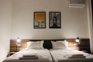 Citro Villa في Gonio: غرفة نوم بسريرين وصورتين على الحائط