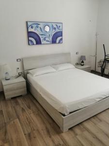 1 dormitorio con 1 cama grande y una pintura en la pared en Delcicer casa vacanze o camera privata, en Galatina