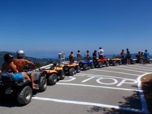 a group of people on atvs parked in a parking lot at Pink Palace Beach Resort in Agios Gordios