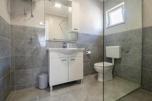 a bathroom with a toilet and a sink and a shower at Apartmani Vuletić in Neum