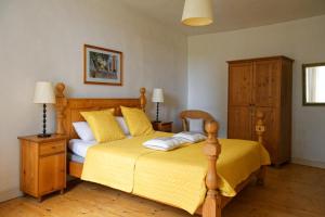 a bedroom with a bed with yellow sheets and yellow pillows at Maison Rives - Village du Livre de Montolieu in Montolieu