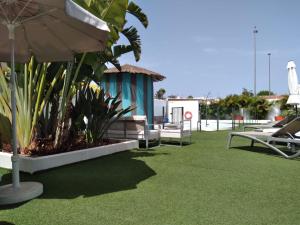 a patio area with lawn chairs and a lawn chair at Starboys Gay Resort - Gay Men Only in Maspalomas