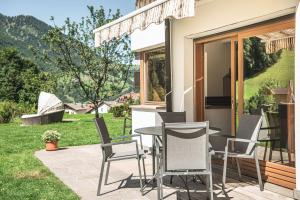 un patio con una mesa y sillas en el césped en Residence Magdalena en Ortisei
