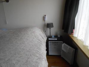 een slaapkamer met een bed en een tafel met een lamp bij Hetem's Room in Amsterdam