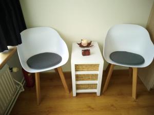 two white chairs sitting next to a small table at Hetem's Room in Amsterdam