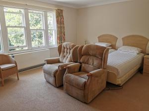 1 dormitorio con 1 cama, 1 silla y 1 sofá en The Grove Hotel en Bournemouth