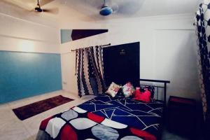 a bedroom with a bed with colorful pillows on it at Ivy Garden View, 2 BHK Private House, Lonavala in Lonavala