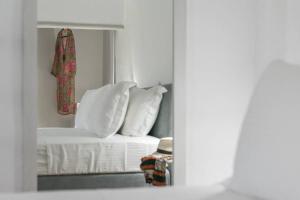 białe łóżko z białymi poduszkami w pokoju w obiekcie CASA ANNA LOFT Boutique House with Full Sea View w mieście Adamas