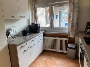 a kitchen with a sink and a window at Hotel Meereswoge in Cuxhaven