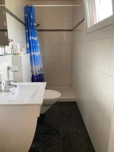 a bathroom with a sink, toilet, and bathtub at Hotel Meereswoge in Cuxhaven