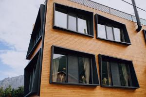 un edificio con ventanas negras con un perro. en Northgate Hotel Kazbegi en Kazbegi