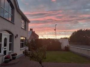a view of a house with a sunset at Mussenden House in Articlave