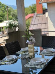 a table with plates and a vase on top at Paradise in Bihać