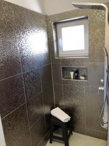 a bathroom with a shower with a stool and a window at Paradise in Bihać