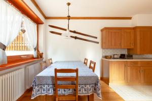 cocina con mesa con 2 sillas y ventana en Antico brolo Mountain lodge, en Gallio
