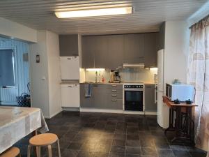 eine Küche mit weißen Geräten sowie einem Tisch und Stühlen in der Unterkunft Tiinan Tallin talo in Seinäjoki