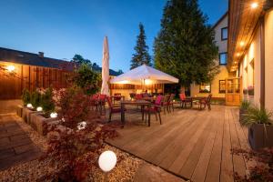 un patio con mesa, sillas y sombrilla en Hotel Zum Steinhof, en Bad Blankenburg