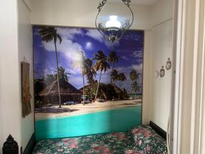 a bedroom with a mural of a beach and palm trees at Mar del Plata frente al mar Biblioteca in Mar del Plata