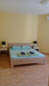 łóżko w pokoju z dwoma stołami i dwoma lampami w obiekcie Apartment Barski w Barze