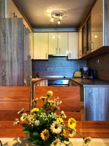 a kitchen with a table with a vase of flowers at Dvosobni apartman in Banjol
