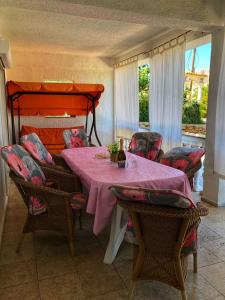 a dining room with a table and chairs and a bed at Dvosobni apartman in Banjol