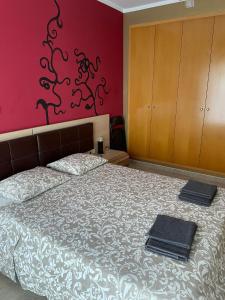 a bedroom with a bed and a red wall at Perfect located family flat in Lloret de Mar