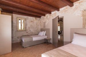 En eller flere senge i et værelse på Elianthos Stone Villa