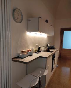 uma cozinha com um balcão e um relógio na parede em LE GRAVINELLE em Ruvo di Puglia