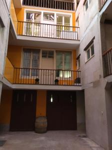 an apartment building with a balcony and a courtyard at Grands Gîtes de charme avec jardin, lieu calme et paisible en plein coeur d'Arbois, linge inclu, lits faits à l'arrivée et ménage en fin de séjour in Arbois