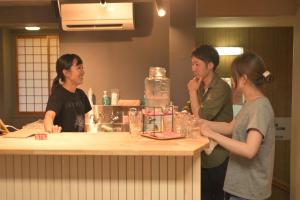 a group of people standing around a counter in a kitchen at Shibu Onsen KADOYA in Yamanouchi