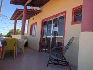eine Terrasse mit Stühlen und einem Tisch auf einem Gebäude in der Unterkunft Pousada O Mineiro - frente para o rio in Galinhos