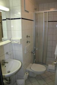 a bathroom with a shower and a toilet and a sink at Hotel Accolo in Feldkirchen