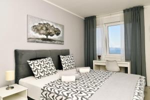 una camera da letto con un letto e un albero sul muro di Mamma Mia Lux Apartment a Fiume (Rijeka)