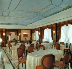 a banquet room with tables and chairs and a ceiling at Andreola Central Hotel in Milan