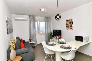 uma sala de estar com um sofá e uma mesa de jantar em Mamma Mia Lux Apartment em Rijeka