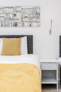 a bedroom with a bed with a yellow pillow and a desk at Spacious 1 Bed Luxury St Albans Apartment - Free WiFi in St. Albans