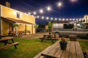 a van parked in a yard with picnic tables and lights at Olle in Ventspils