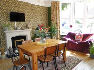 a living room with a wooden table and a fireplace at Rockleaze Guesthouse in Bristol