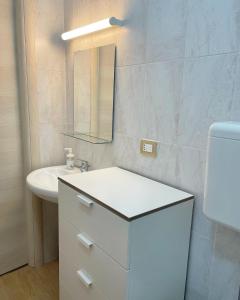 een witte badkamer met een wastafel en een spiegel bij B&B Acqua Azzurra in Castellammare di Stabia