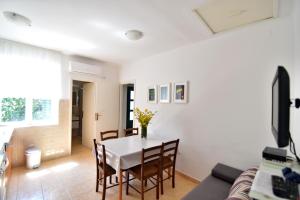 a living room with a white table and chairs at Apartmani Badurina - Crnika in Lun