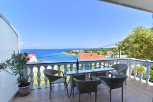 a balcony with a table and chairs and the ocean at Apartmani Badurina - Crnika in Lun